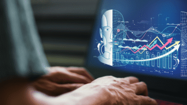 Close-up of hands typing on a keyboard with a holographic AI/data analytics display projected on a screen to the right, showing charts and rising arrows in blue tones.